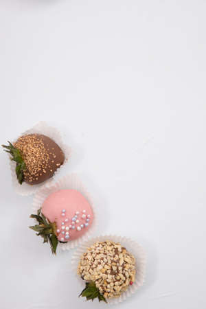 Assorted strawberries in chocolate, sweet dessert, berries in different chocolate and sprinkled with nuts.の写真素材