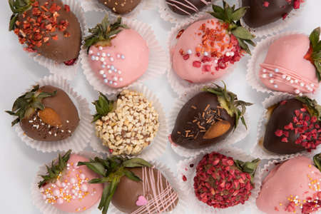 Variety of strawberries covered with chocolate, dark and white chocolate and nuts.の写真素材