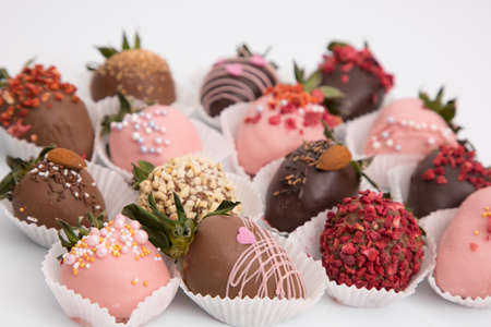 Assorted strawberries in chocolate, sweet dessert, berries in different chocolate and sprinkled with nuts.の写真素材