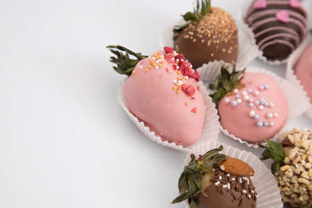 Assorted strawberries in chocolate, sweet dessert, berries in different chocolate and sprinkled with nuts.の写真素材
