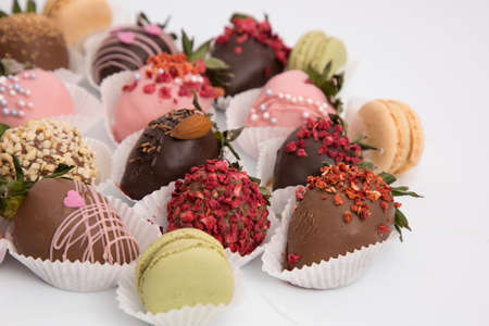 Assorted strawberries in chocolate, sweet dessert, berries in different chocolate and sprinkled with nuts.の写真素材