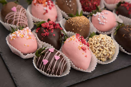 Assorted strawberries in chocolate with macaron, sweet dessert, free space for your text, sprinkled with nuts, top view, isolated background.の写真素材