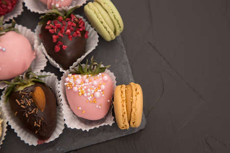 Assorted strawberries in chocolate with macaron, sweet dessert, free space for your text, sprinkled with nuts, top view, isolated background.の写真素材