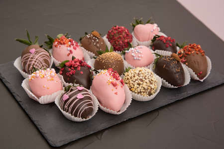 Assorted strawberries in chocolate with macaron, sweet dessert, free space for your text, sprinkled with nuts, top view, isolated background.の写真素材