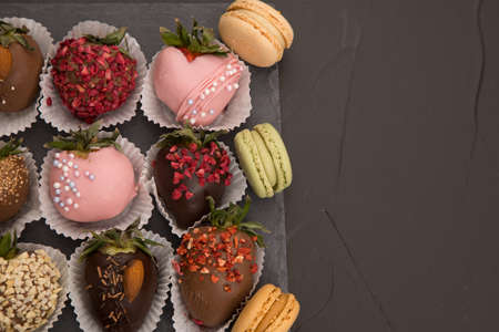 Assorted strawberries in chocolate with macaron, sweet dessert, free space for your text, sprinkled with nuts, top view, isolated background.の写真素材