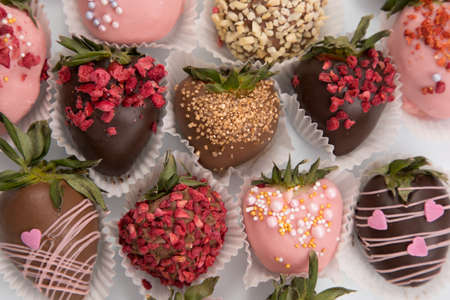 Variety of strawberries covered with chocolate, dark and white chocolate and nuts.の写真素材