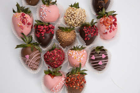 Assorted strawberries in chocolate, sweet dessert, berries in different chocolate and sprinkled with nuts.の写真素材