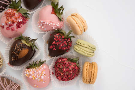 Assorted strawberries in chocolate, sweet dessert, berries in different chocolate and sprinkled with nuts.の写真素材