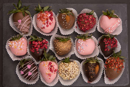 Assorted strawberries in chocolate with macaron, sweet dessert, free space for your text, sprinkled with nuts, top view, isolated background.の写真素材