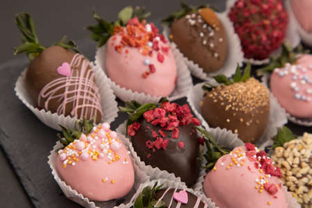 Assorted strawberries in chocolate with macaron, sweet dessert, free space for your text, sprinkled with nuts, top view, isolated background.の写真素材