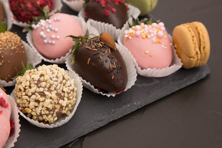 Assorted strawberries in chocolate with macaron, sweet dessert, free space for your text, sprinkled with nuts, top view, isolated background.の写真素材