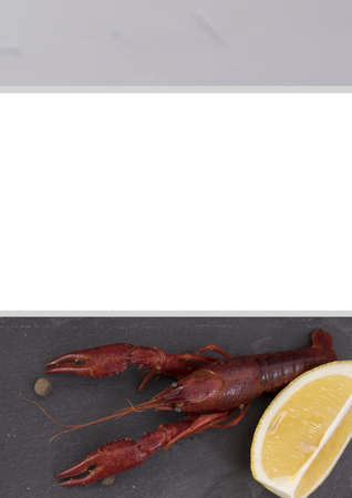 Delicious boiled crayfish close-up on a stone plate with lemon and parsley.の写真素材