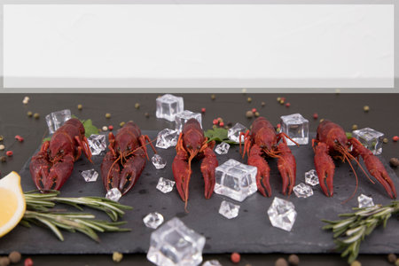 Delicious boiled crayfish close-up on a stone plate with lemon and parsley.の写真素材