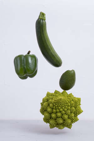 Fresh green vegetables on the table. zucchini, pepper, avocado, Romanesco broccoli, Floating food balance concept, levitation.の写真素材