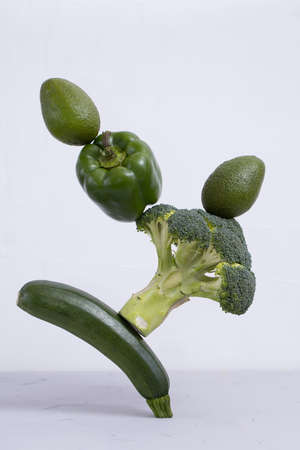 Fresh green vegetables on the table. zucchini, avocado, pepper, and broccoli, Floating food balance concept, levitation.の写真素材