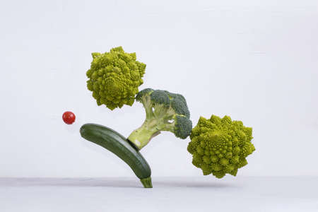 Fresh green vegetables on the table. zucchini, Romanesco broccoli, cherry tomato, Floating food balance concept, levitation.の写真素材