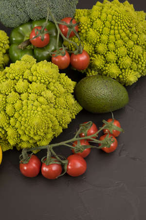 fresh vegetable, romanesco broccoli, pepper, zucchini, lemon and avocado, free space in your text, on a black table.の写真素材
