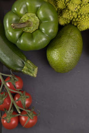 fresh vegetable, romanesco broccoli, pepper, zucchini, avocado and cherry tomato, free space in you text, on a black table.の写真素材