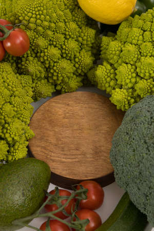 fresh vegetable, romanesco broccoli, zucchini, avocado, lemon and cherry tomato, free space in your text on a wooden board.の写真素材