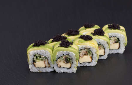 Sushi Rolls Green dragon roll with RICE, EEL, JAPANESE OMLET, cucumber, avocado and MASAGO.の写真素材