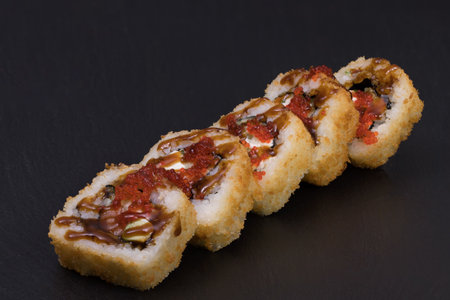 Sushi Rolls Sake Tempura with RICE, SALMON, CREAM CHEESE, cucumber, avocado, TOBIKO and TERIJAKI sauce.の写真素材