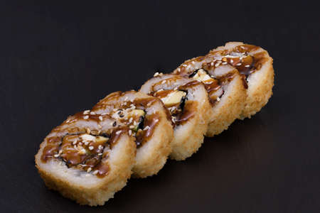 Sushi Rolls Unagi Tempura with RICE, CREAM CHEESE, avocado, paprika, CRAB STICKS, EEL, SESAME and TERIJAKI sauce.の写真素材