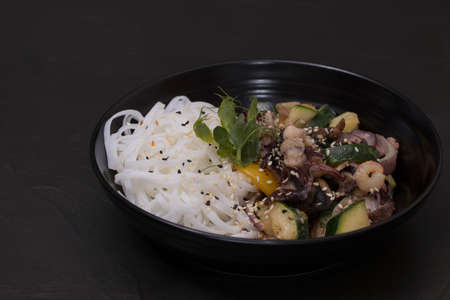 Plate of wok with seafood, on a black background.の写真素材