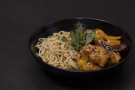 Plate of wok with chiken, on a black background.の写真素材