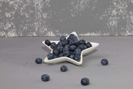 Fresh blueberry in court, on a gray background.の写真素材