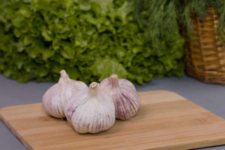 Garlic cloves on the wooden desk and gray background.の写真素材