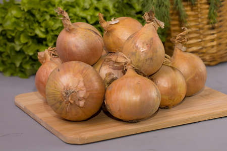 Onions on a wooden cutting board.の写真素材