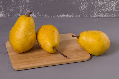 Yellow Pear on a wooden desk and gray background.の写真素材
