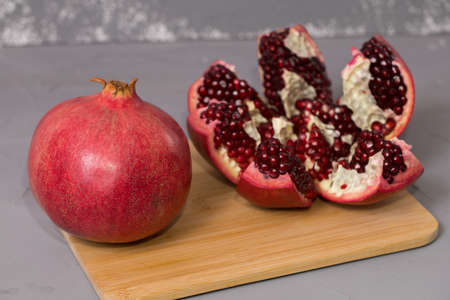 Open frash pomegranate on a wooden desk, pomegranates in the background.の写真素材