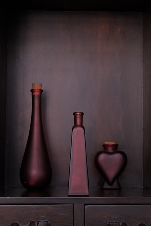 Three red matte glass bottle on the commodeの写真素材