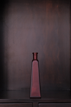 One red matte glass bottle on the commodeの写真素材