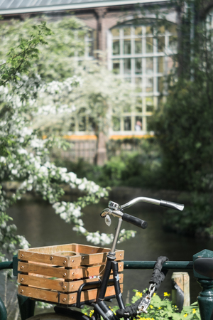 Part of the bicycle with a basket on the background of a blurred building with big windowsの写真素材