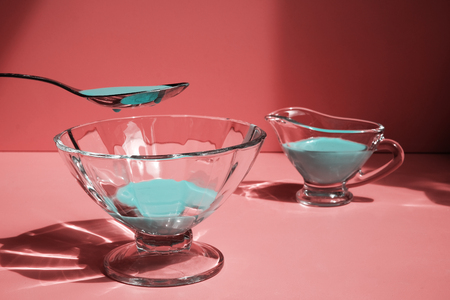 Blue liquid in a spoon above a glass tray in the background of a cherryの写真素材