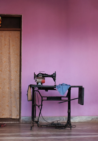 Sewing machine in the courtyard against the background of a purple wallの写真素材