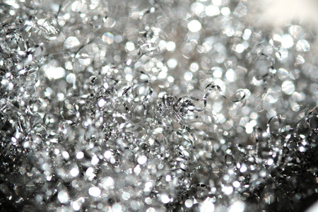 Silver shiny serpentine tinsel close up with blured backgroundの写真素材