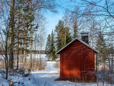The old bathhouse in the woods by the lake, clear winter day.のeditorial素材