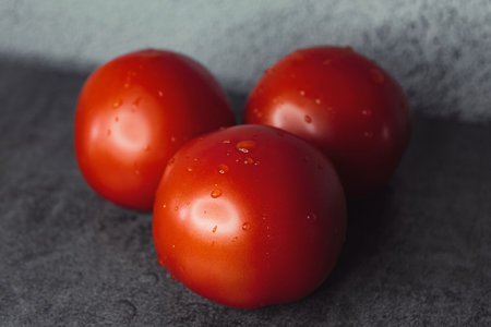 red tomatoes on the table with drops of waterの写真素材