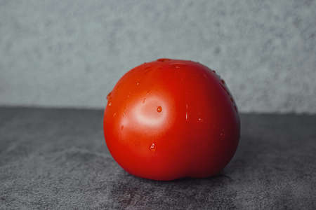 red tomatoes on the table with drops of waterの写真素材