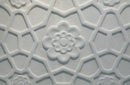 Indian style white flower symmetrical ornament on marble wallの写真素材