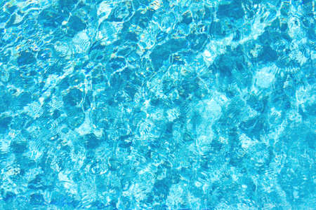 Splashes of blue water in the pool. Textured background. Top view, copy space.の写真素材