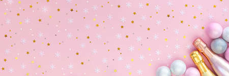Banner with two bottles of champagne, silver Christmas balls, snowflakes and gold stars on a pink background. Beautiful layout for the New Year.の写真素材