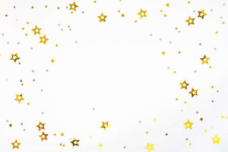 Shiny confetti of gold and silver color on a white background. Festive background. Frame, flat lay,...