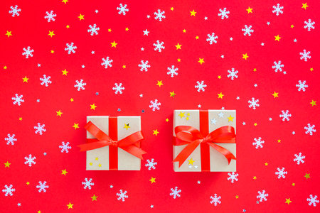 Two New Years gifts with white snowflakes and gold stars on red. New Year, Christmas background.の写真素材