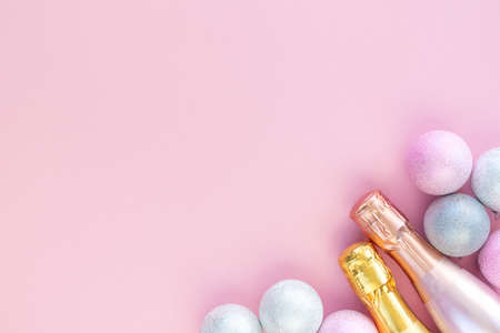Two beautiful bottles of champagne on a pink background with silver Christmas balls. Beautiful mockup for New Year and xmas.の写真素材