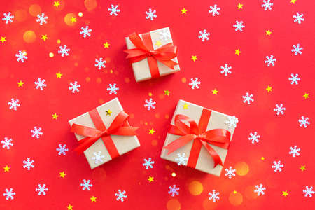 Three New Year's gifts with white snowflakes and gold stars on red. Christmas background, flat lay.の写真素材