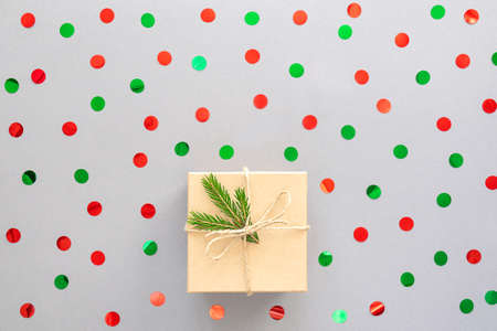 New Year background or Christmas card. Beige gift box, fir branch and confetti. Top view, copy space.の写真素材